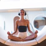 woman in headphones lounges on a circular bed